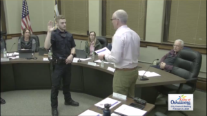 Cale Holmberg being sworn in as an Oskaloosa Police Officer by Mayor Pro Tem Bob Drost. (image from city council broadcast)